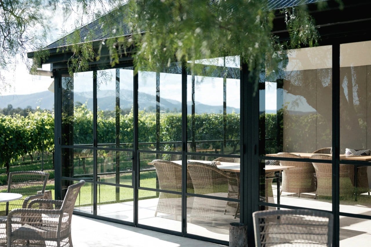Visitor in cellar door lounge with vineyard views at sunrise
