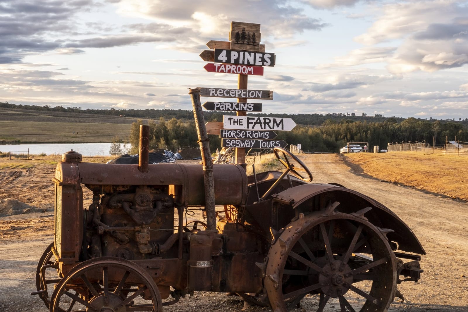 Vintage tractor signpost pointing to the taproom, reception and the Farm