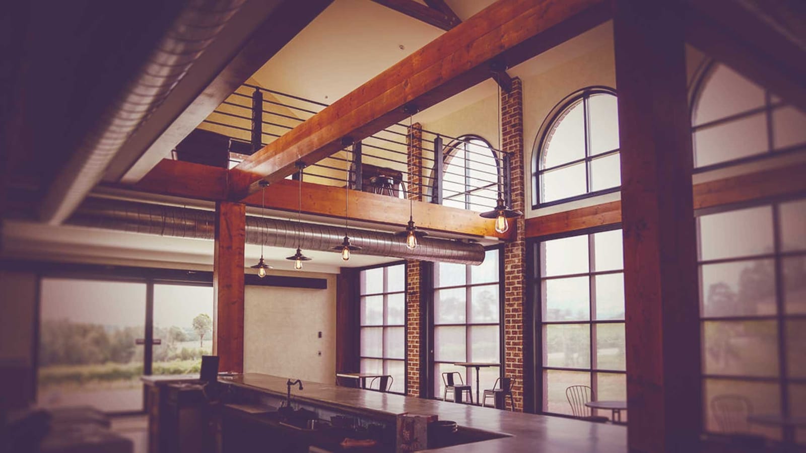 Cellar door interior with timber beams and arched vineyard windows