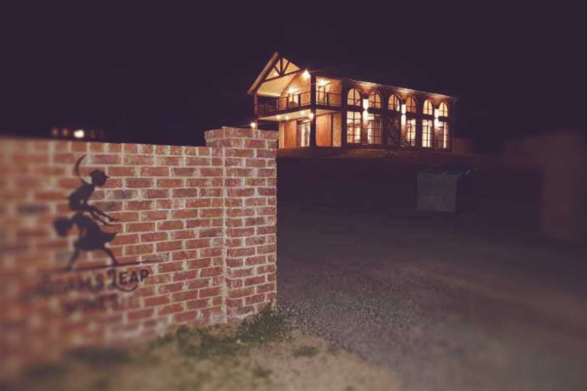 Brick cellar door building illuminated at dusk with arched windows