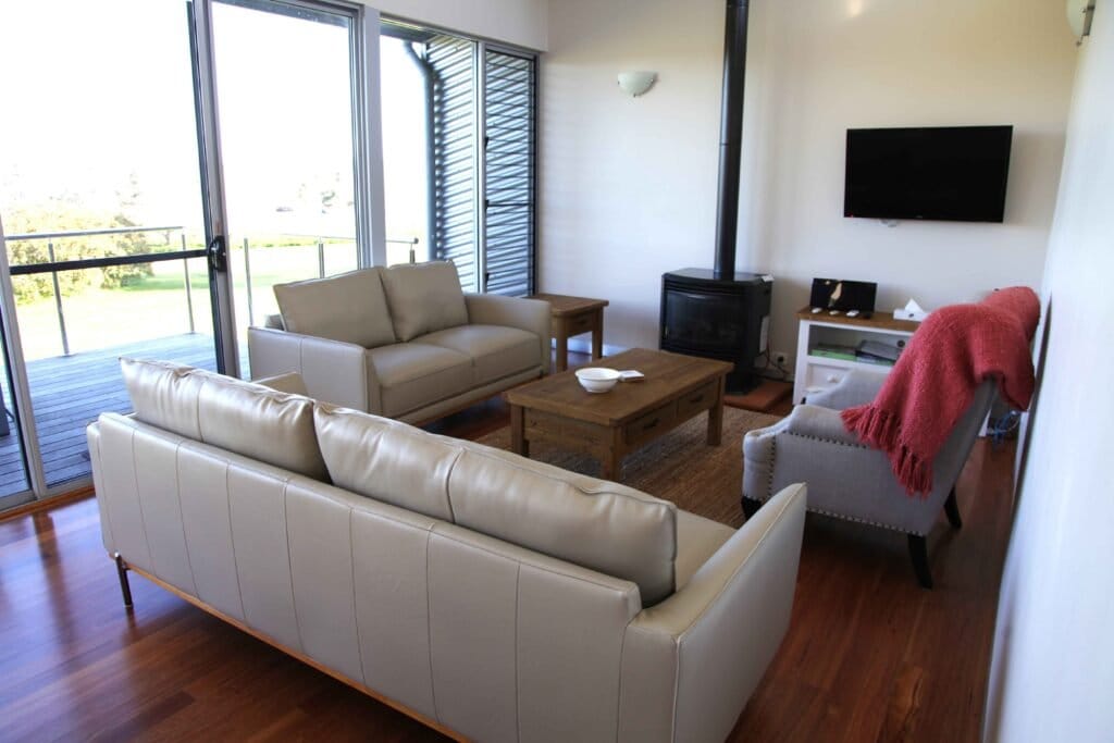Living room with sofas, fireplace and vineyard views through windows