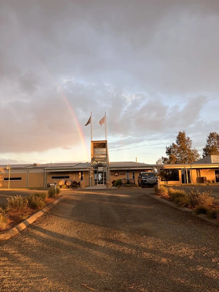 Cellar door building at sunset with flags and entrance signage at Adina, Lovedale, Hunter Valley