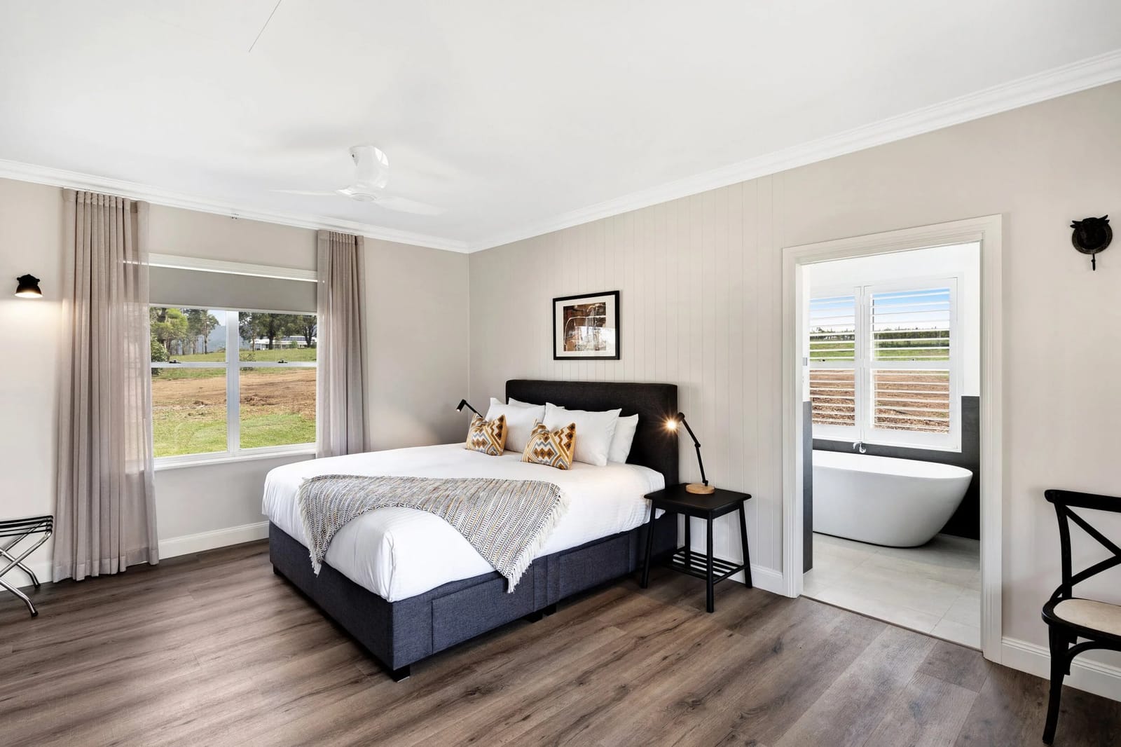 The king bedroom with a view over open paddock, opening through to the ensuite bathroom