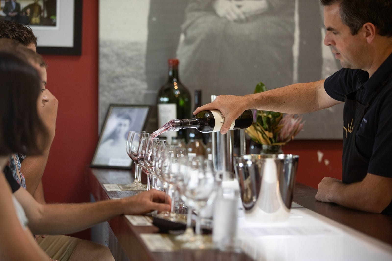A host pouring a red wine tasting at the Audrey Wilkinson cellar door