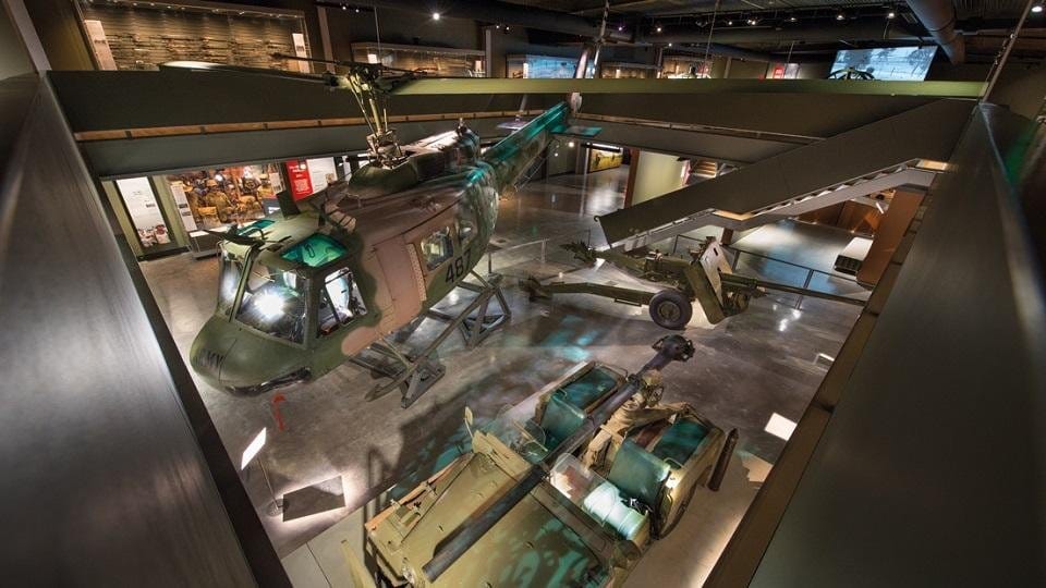 The lower floor gallery seen from above, with a helicopter, field guns and an armoured vehicle