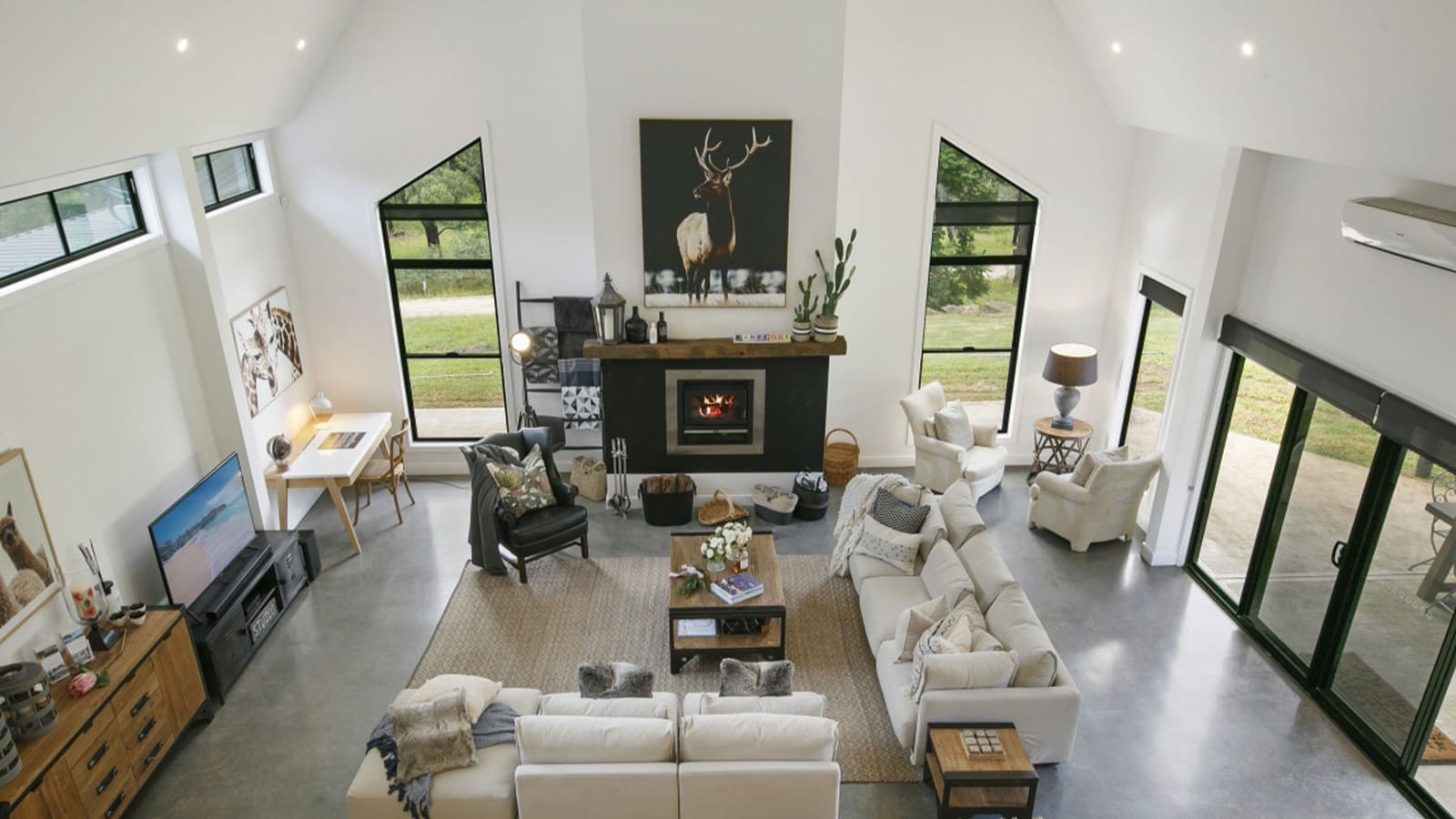 Modern villa interior with multiple sofas and fireplace at Barefoot at Broke, Broke Fordwich, Hunter Valley