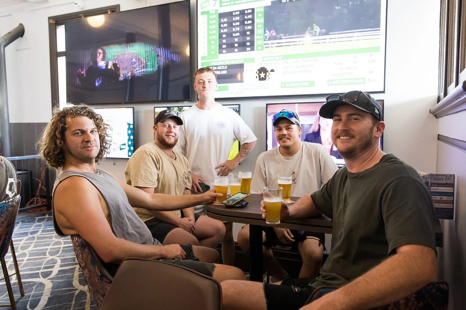 Guests watching live sports while enjoying drinks in hotel bar