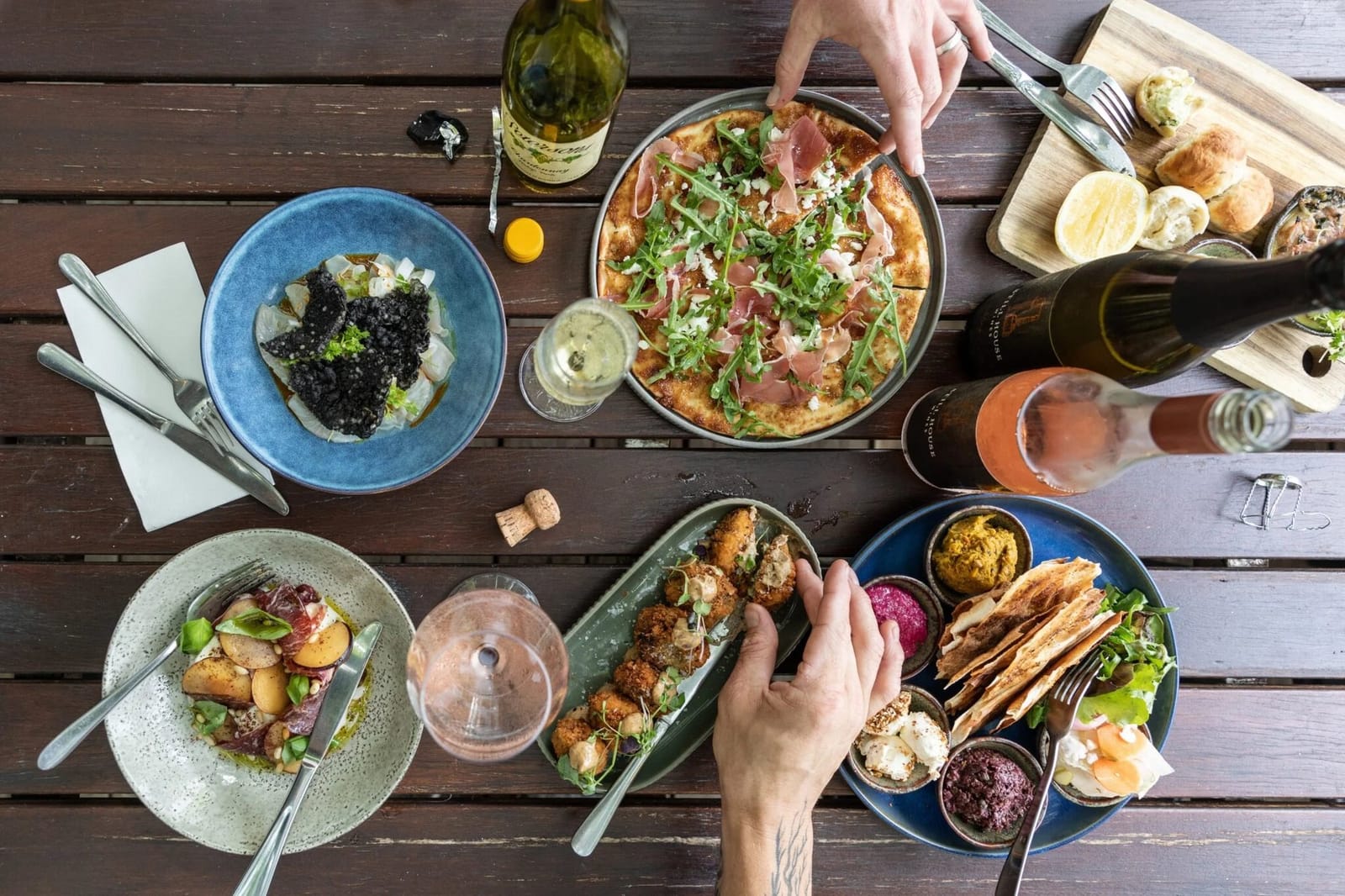 Wine pairing feast with salads, pizza and cured meats on table
