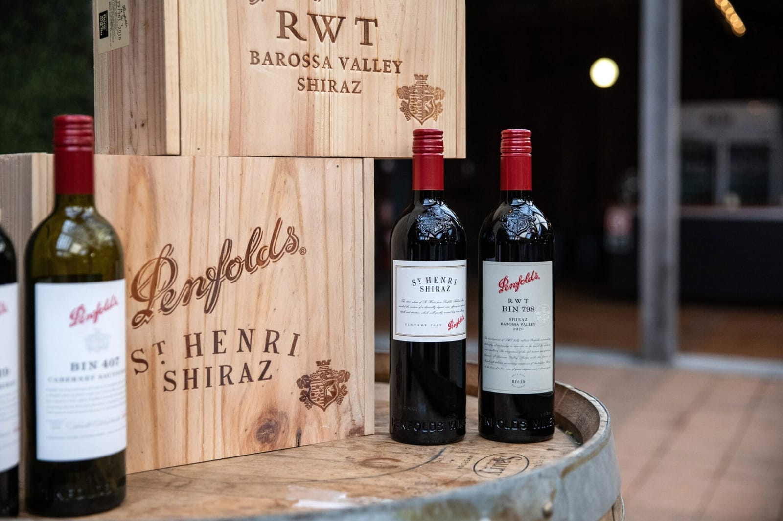 Penfolds wine bottles displayed on wooden barrel with vintage labels