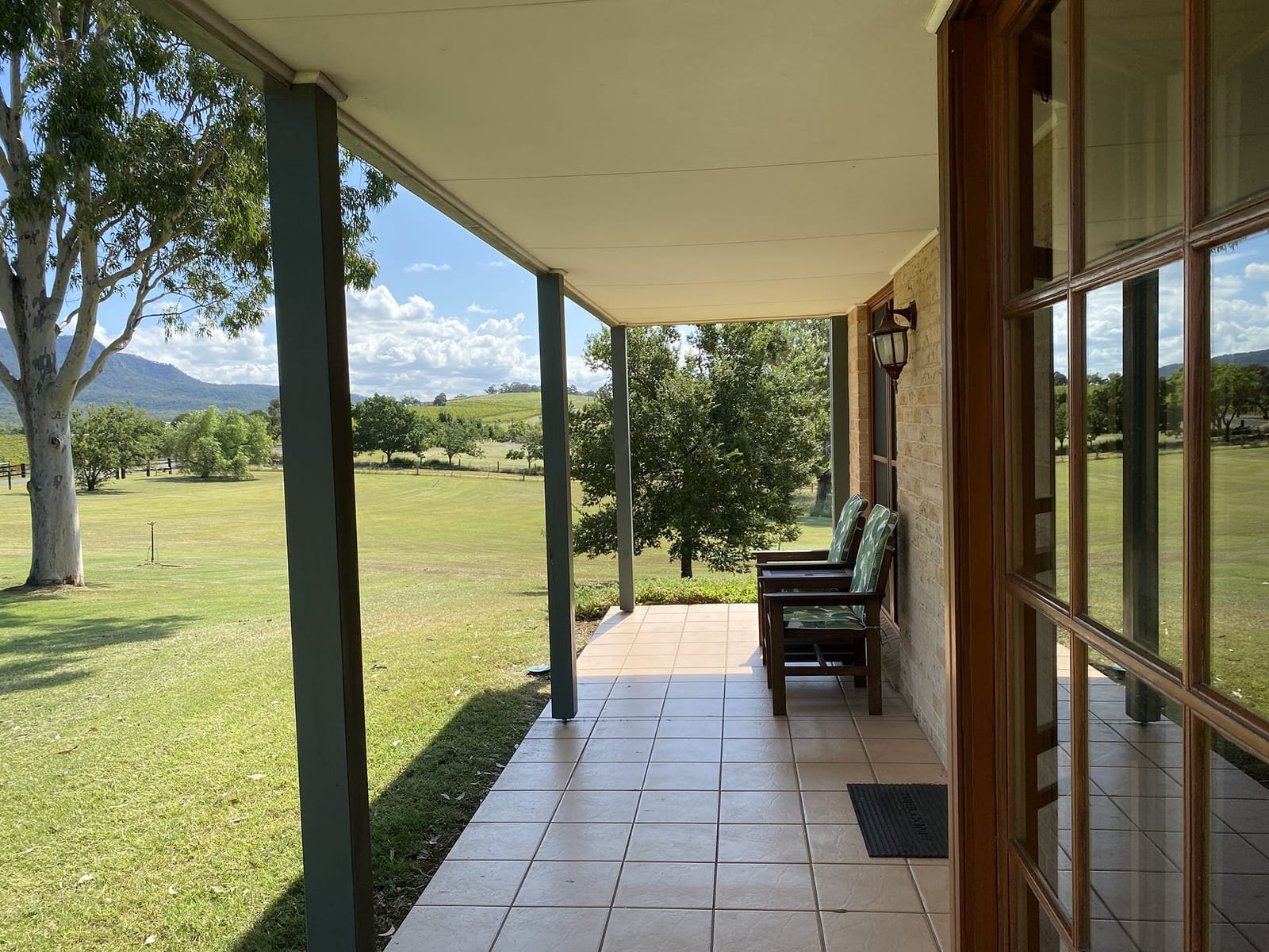 Outdoor seating on a cottage verandah looking over the paddocks