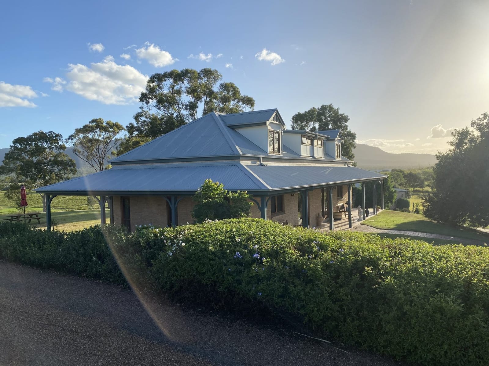 Colonial-style house at sunset seen from the driveway at Berenbell Vineyard Retreat, Pokolbin, Hunter Valley