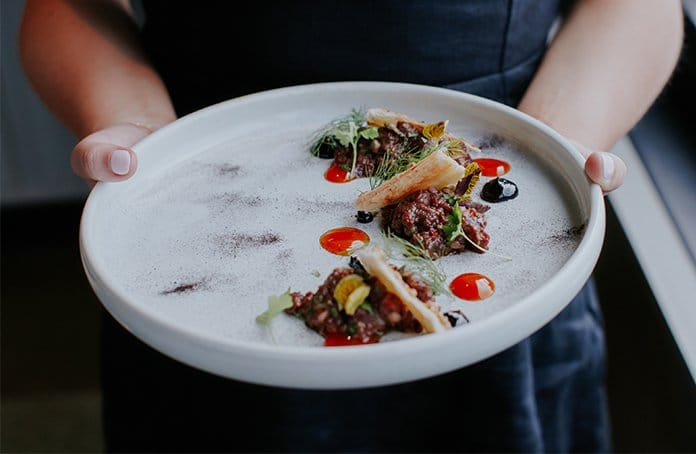 Fine dining plated dish with meat, vegetables and garnishes