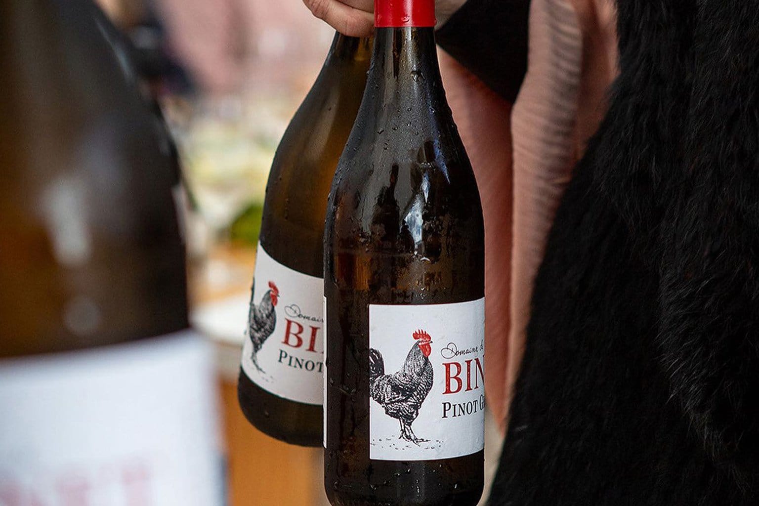Binet pinot noir bottle with rooster label being held