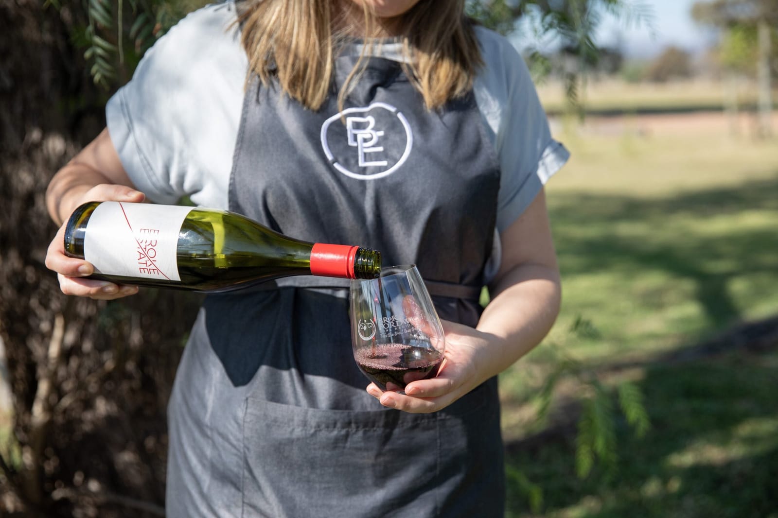A bottle of Broke Estate wine being poured at an event