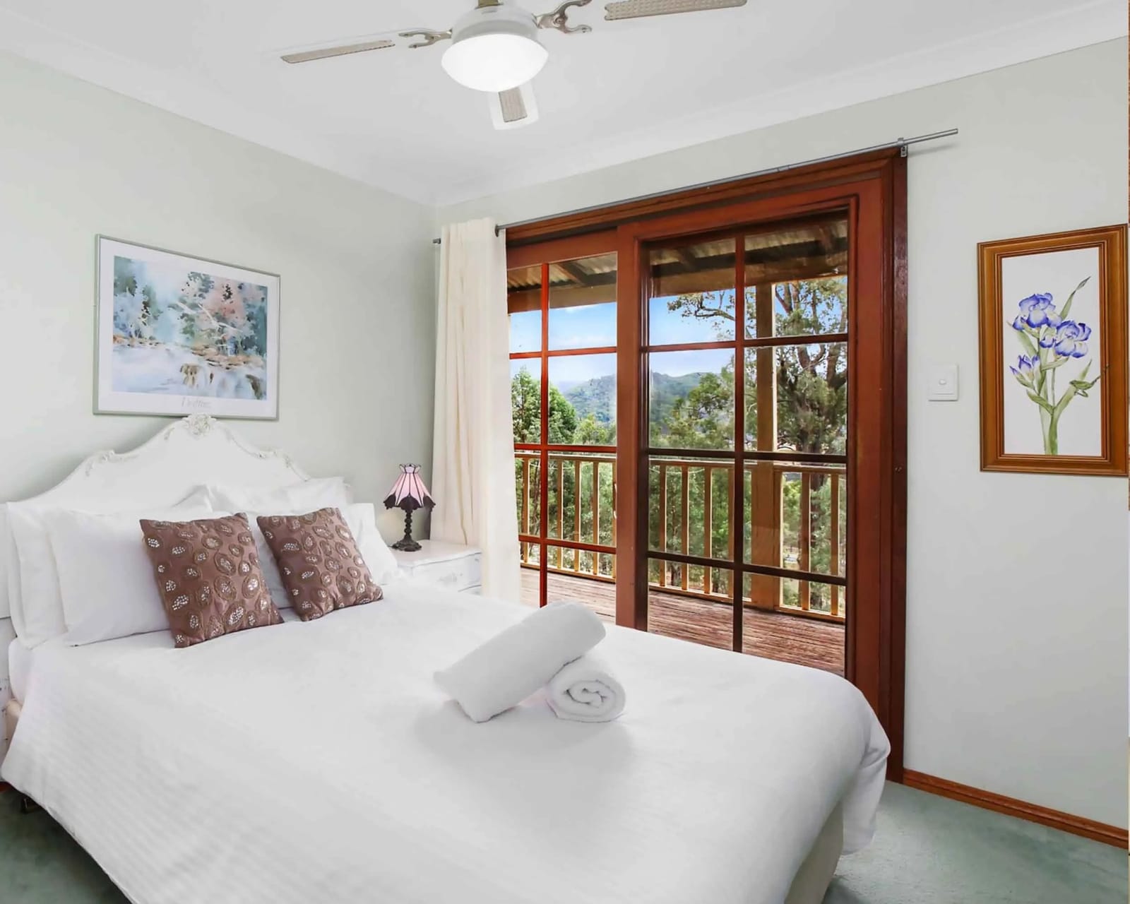 A bedroom at Cant's Cottage with a queen bed and a balcony over the valley.