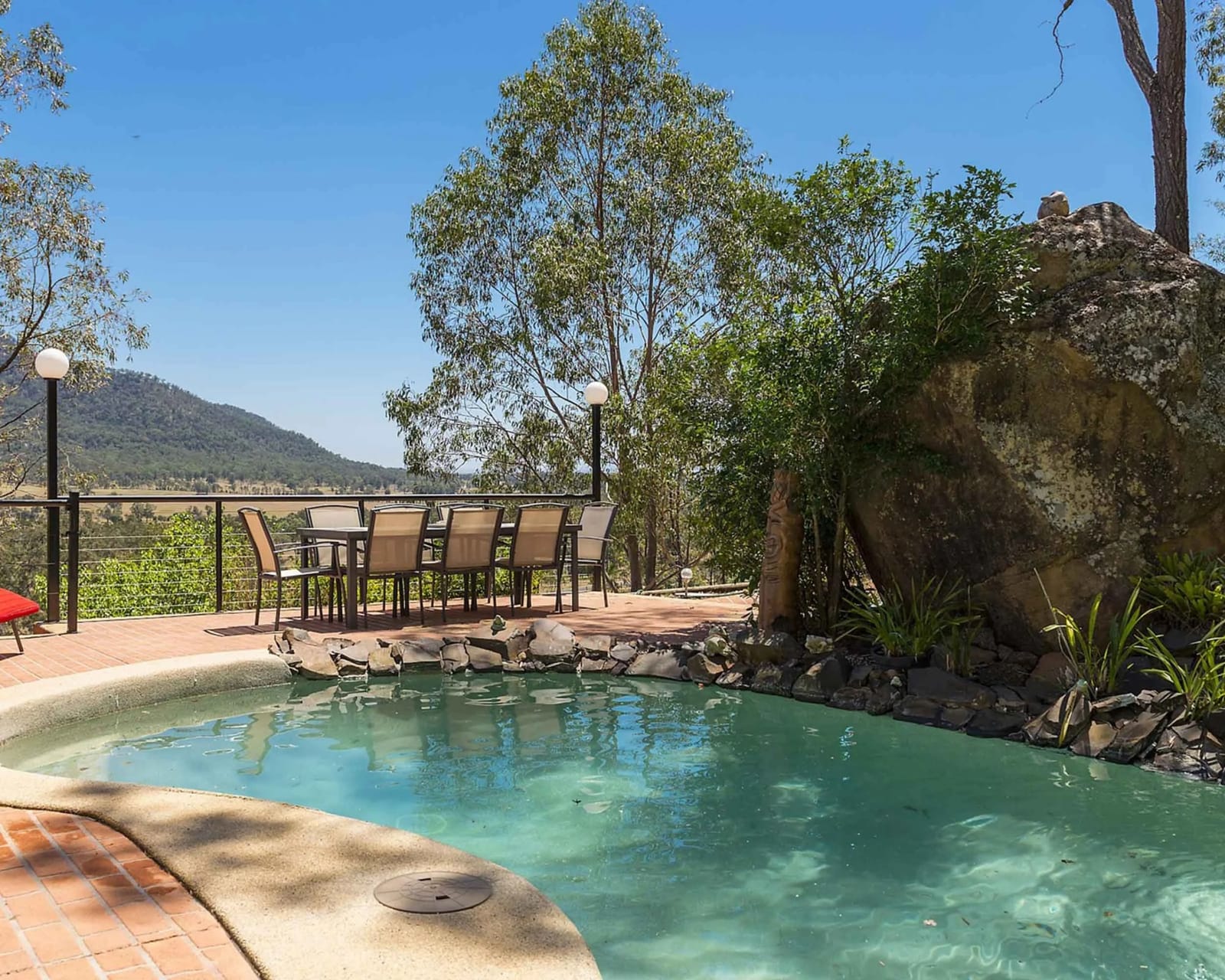 The private pool at Cant's Cottage with a dining table and a view over the Broke valley.