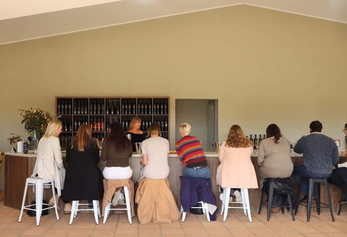 Cellar door tasting counter with wine bottles and visitors at Capercaillie, Lovedale, Hunter Valley
