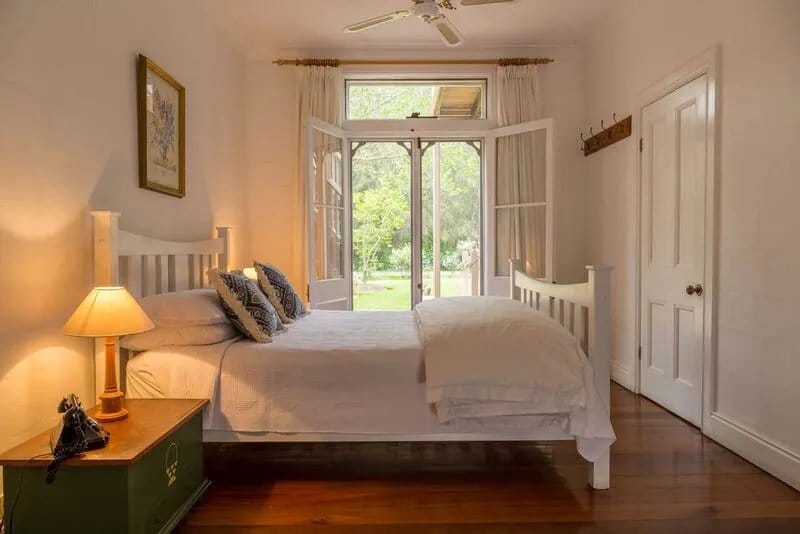 Guest bedroom with double bed and garden views through doors
