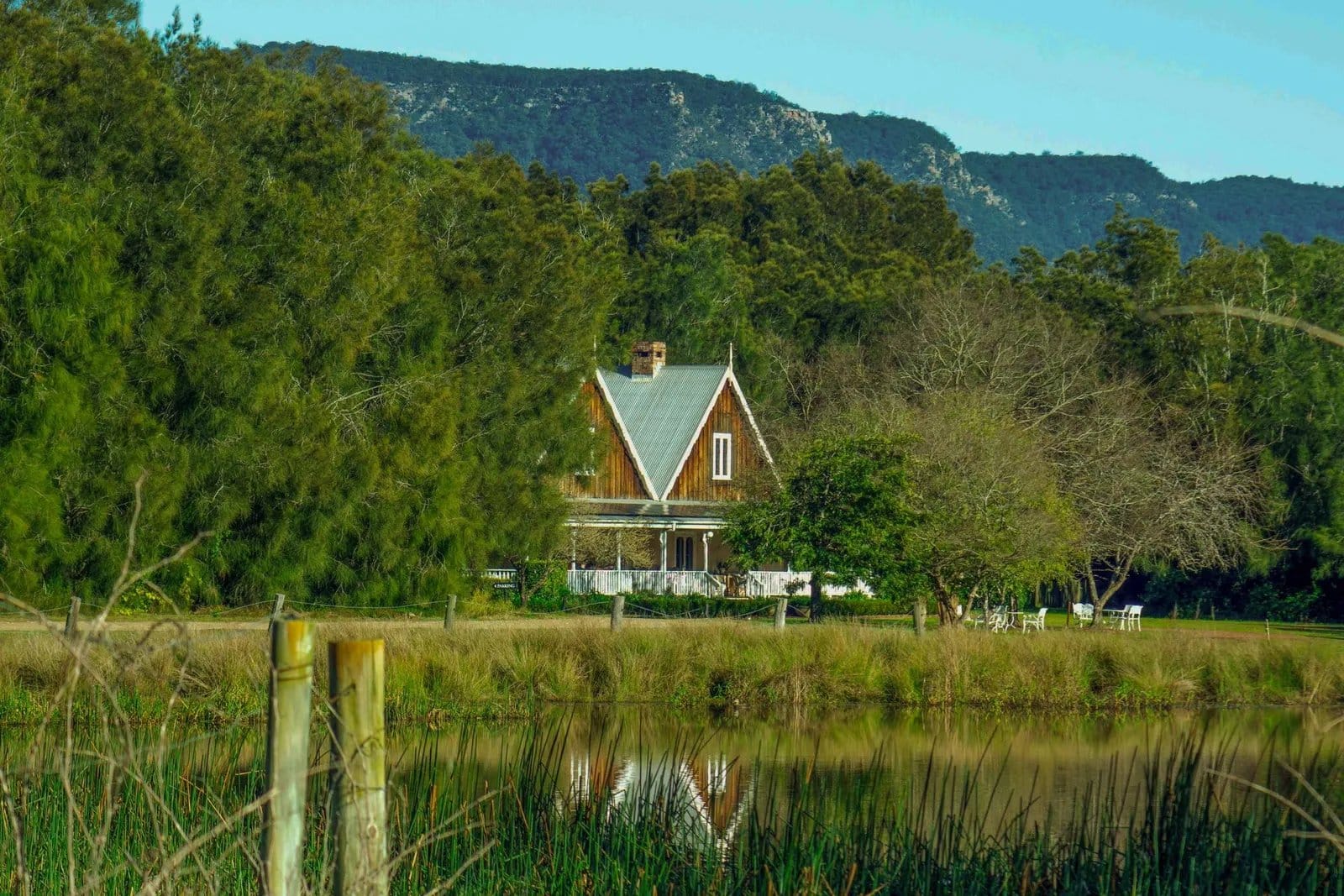 Estate building viewed across pastoral landscape with water