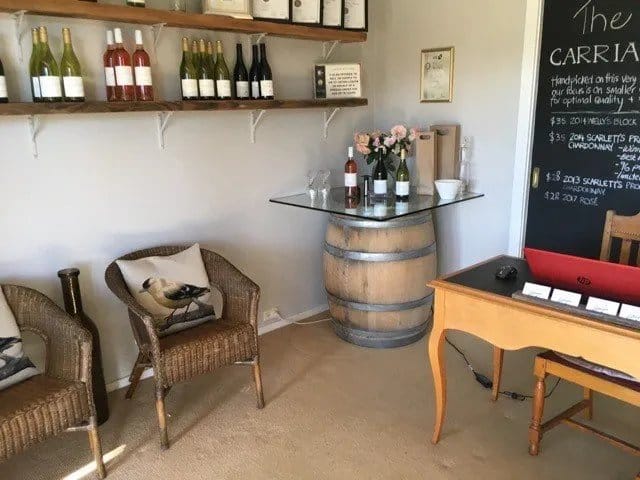 Wine bottles displayed on wooden shelving in cellar door