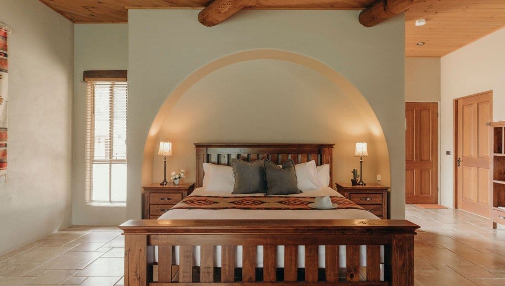 A bedroom in Spa Villa One under a curved rendered arch