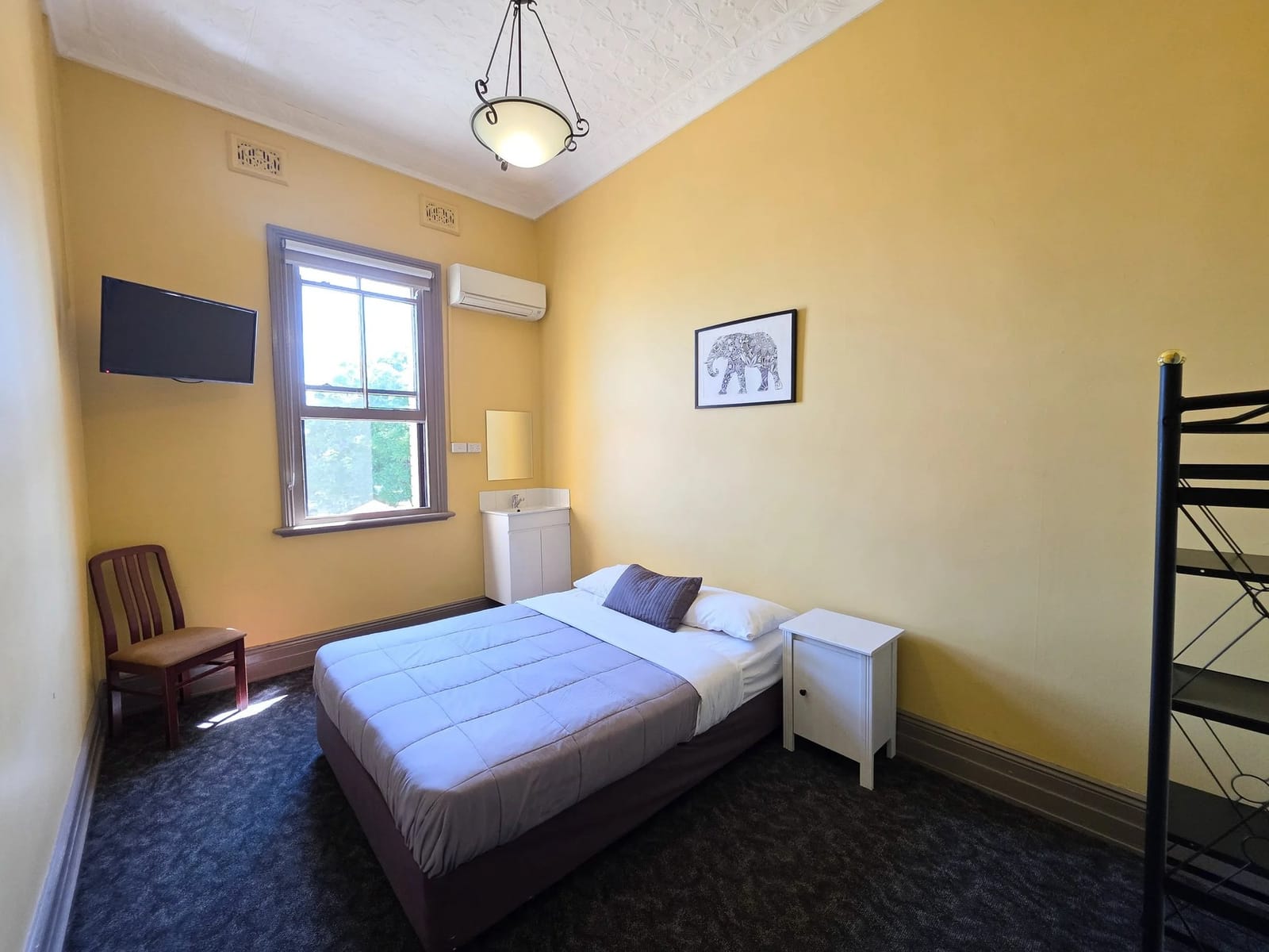 Vintage Queen room with yellow walls and forest views at Cessnock Hotel, Hunter Valley