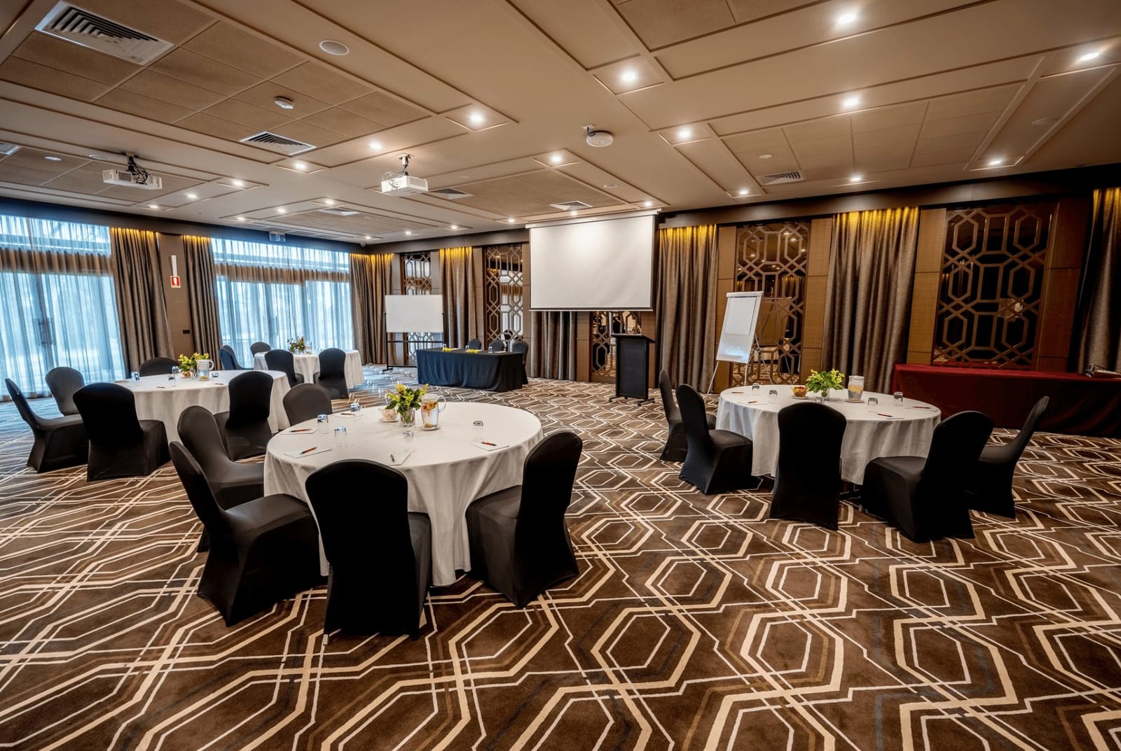The Chateau Elan function room laid out with round tables and a projector screen