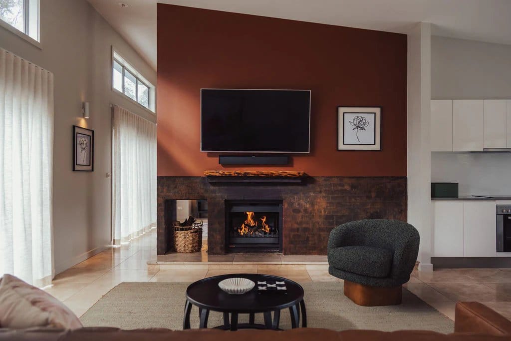 The villa living area with its dual-sided stone fireplace, open through to the kitchen on the other side