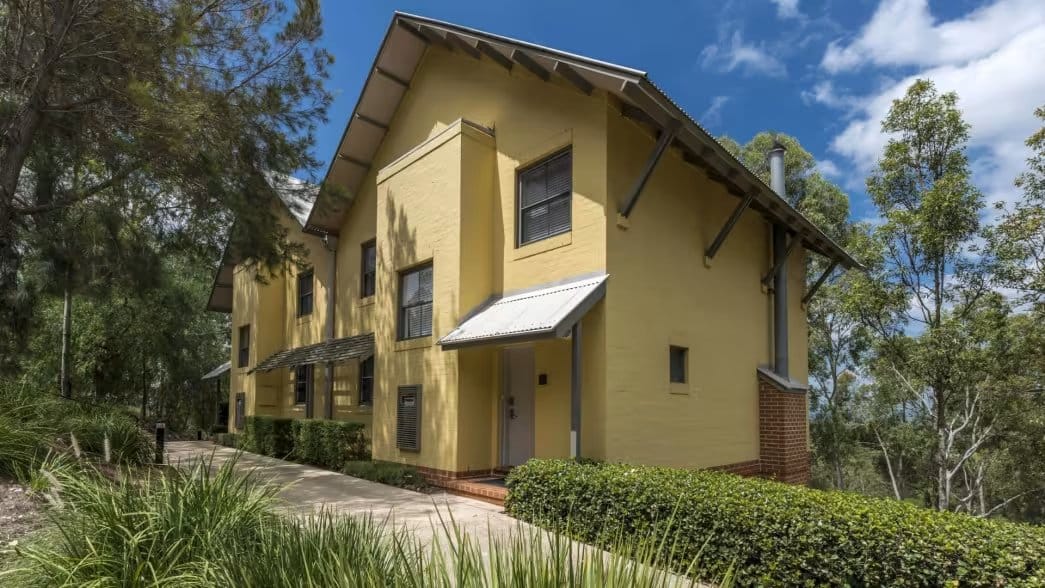 Yellow and brick lodge building with manicured grounds
