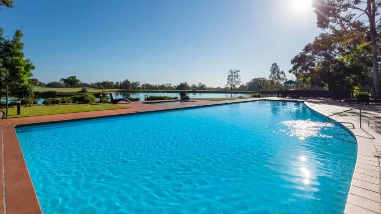 Swimming pool with timber deck surrounded by grassy grounds