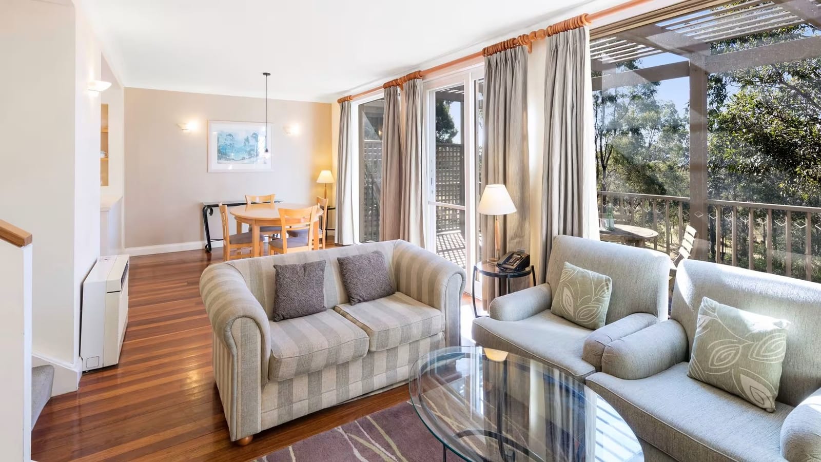 Suite interior with lounge seating and balcony overlooking gardens