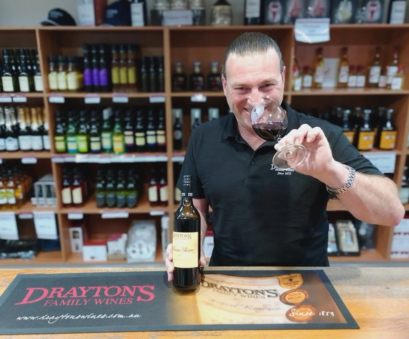 Pourer nosing a glass behind the cellar door counter at Draytons, Pokolbin, Hunter Valley