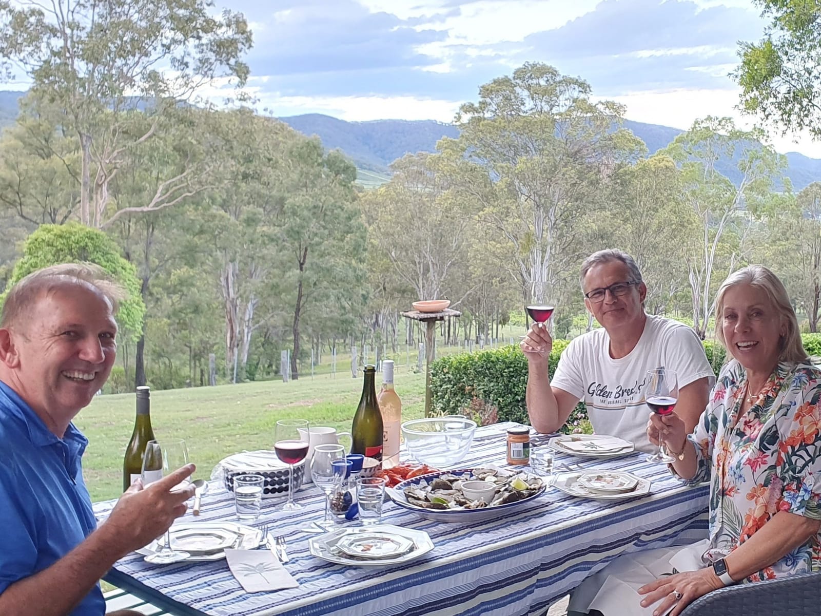 Group dining outdoors overlooking mountains and eucalyptus forest at Elfin Hill, Pokolbin, Hunter Valley