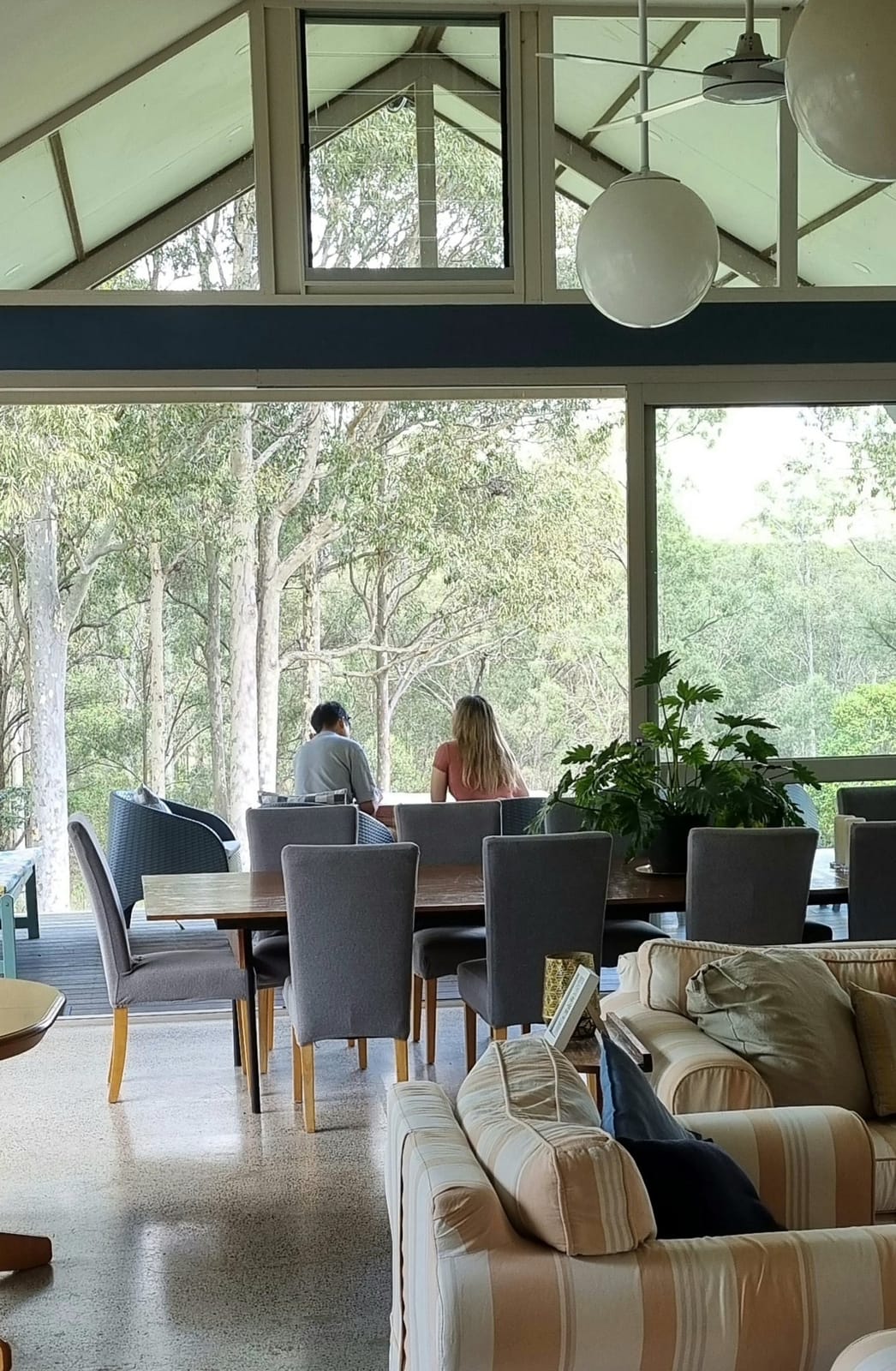 Lounge interior with large windows framing forest and mountain views