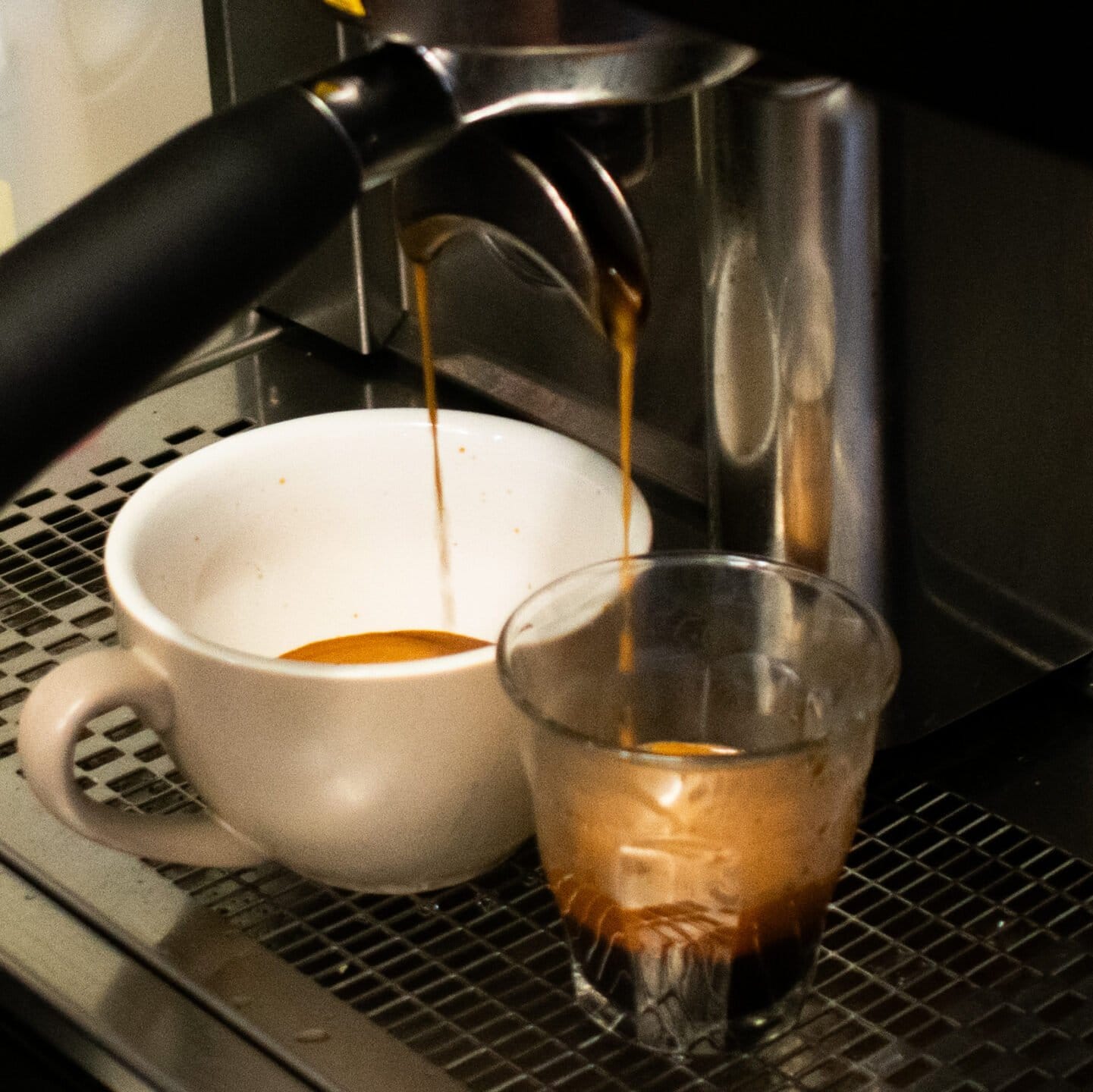 Espresso pouring from the machine into a cup and glass at Elliotts at Oakvale.
