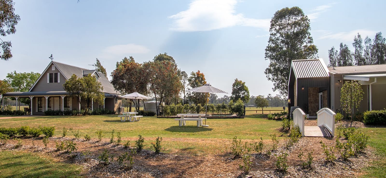 Multiple buildings across property with picnic tables and vineyard rows