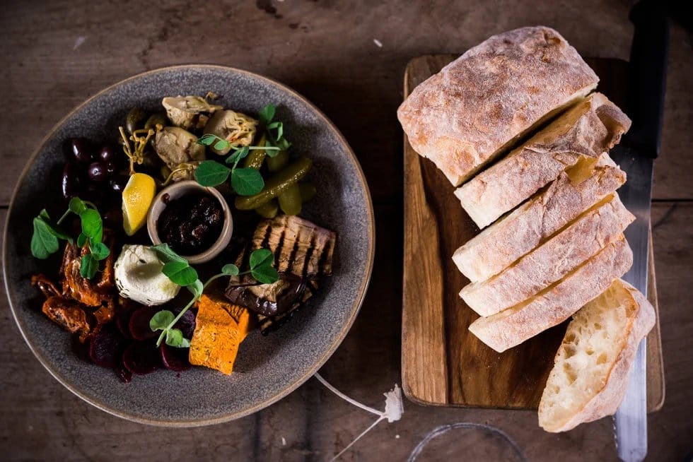 Plated vegetable dish and cured meats board with artisan bread at Enzo, Pokolbin, Hunter Valley