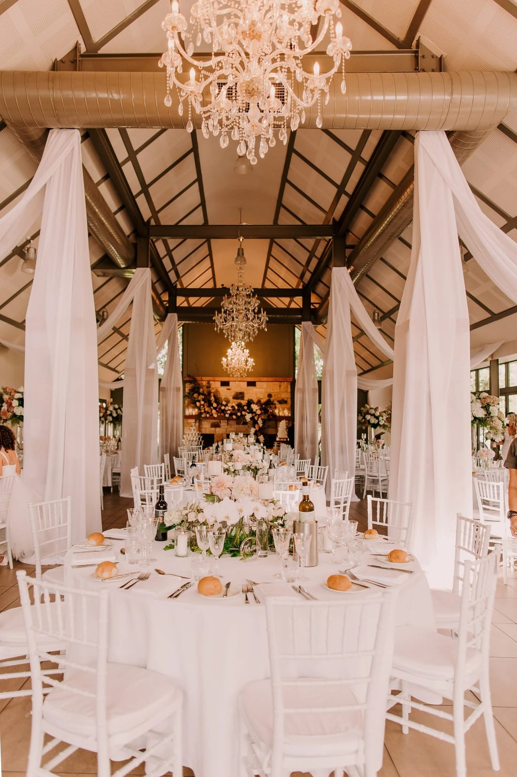 Grand dining hall with crystal chandeliers and white linen tables
