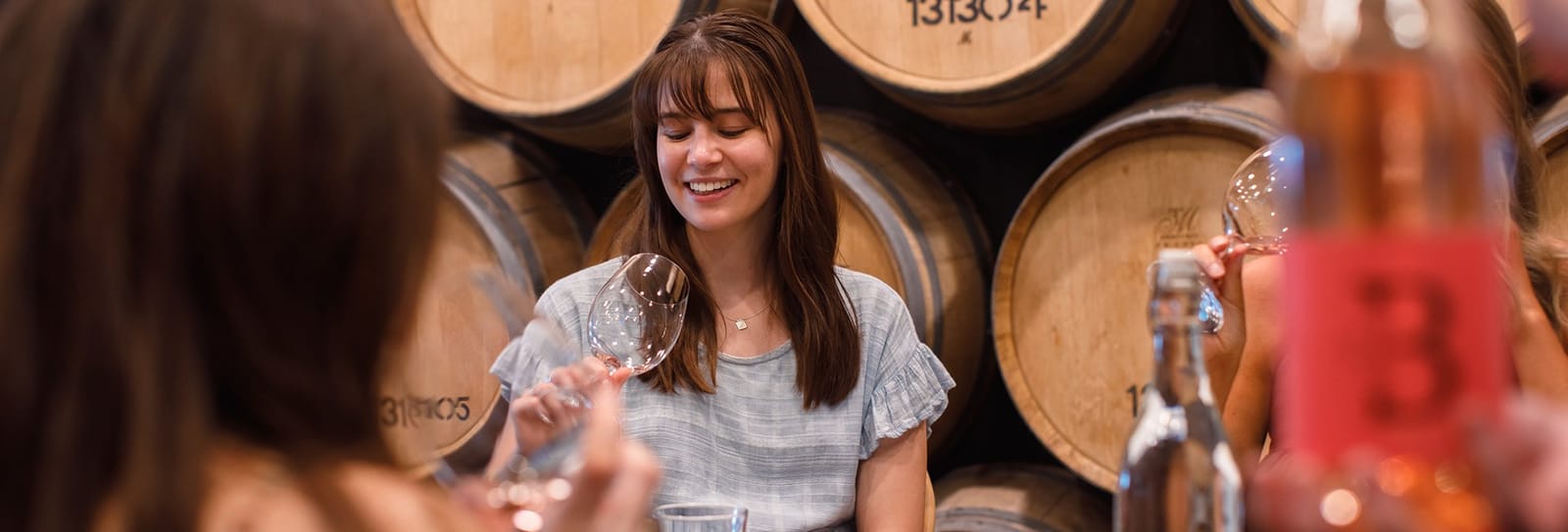 Guests tasting wine among the barrels at Bimbadgen