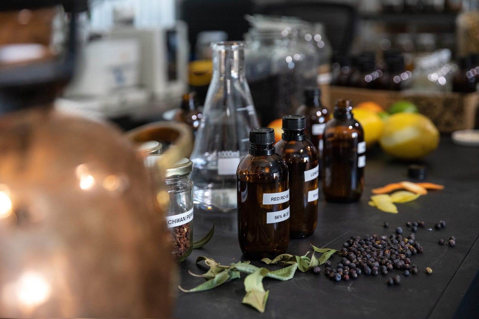 Amber bottles, glassware and botanicals laid out on a bench at FAR Distilling