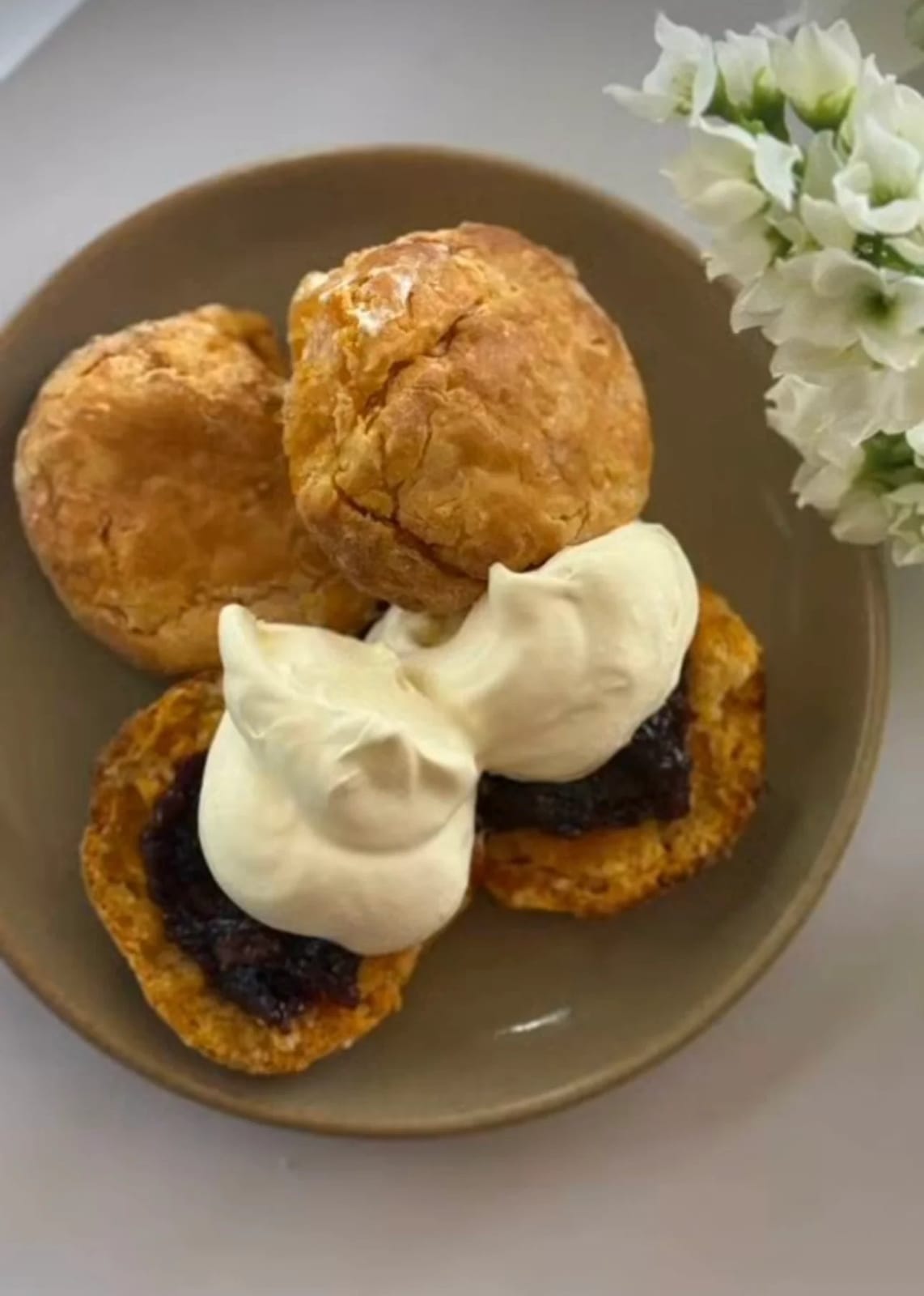 Warm scones with jam and cream on a plate at Flock & Fork.