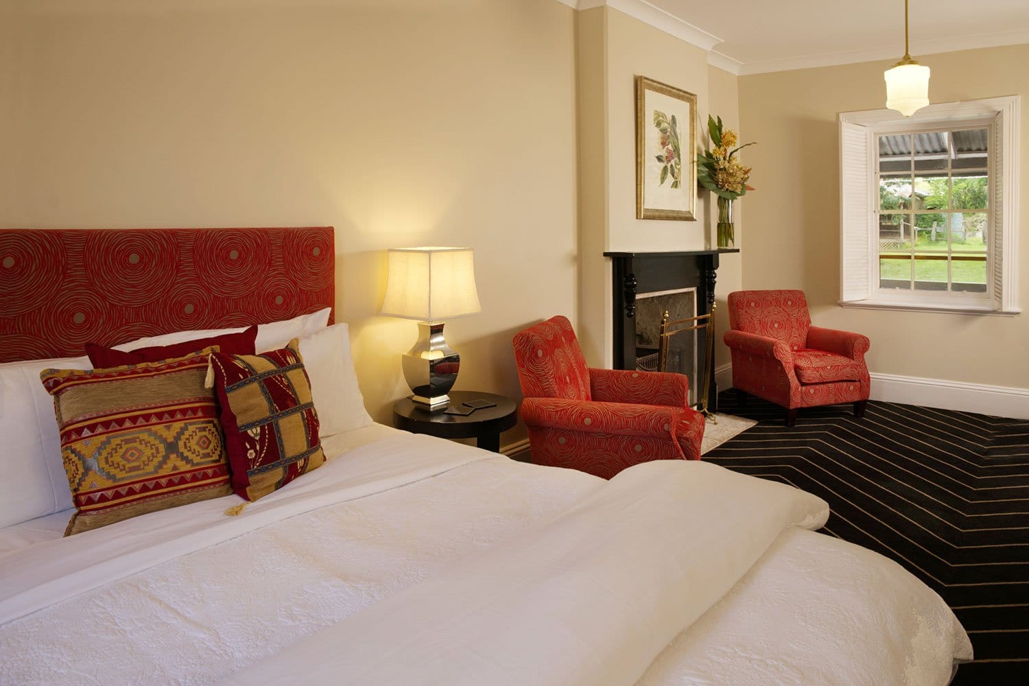 Guest room with double bed, red velvet headboard and working fireplace