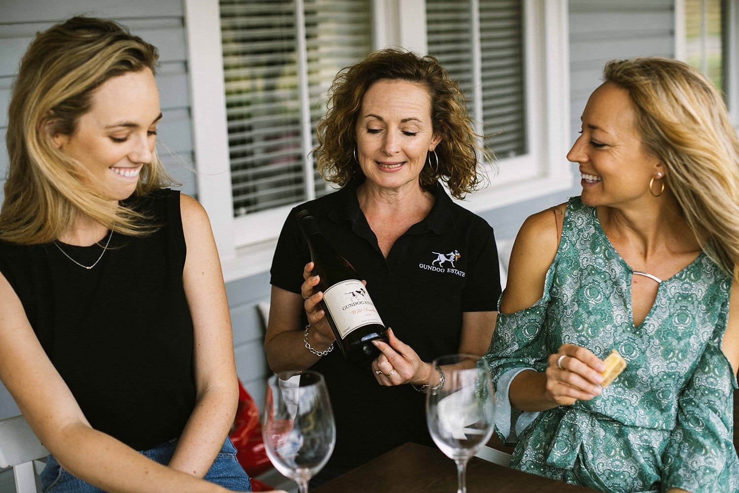 Gundog staff member presenting wine to guests during a tasting experience