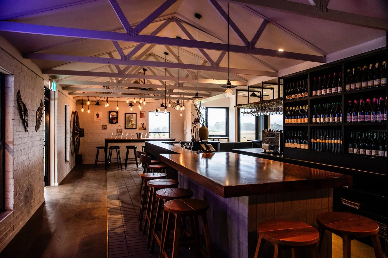 Modern tasting room with exposed beams, timber bar and wine racks