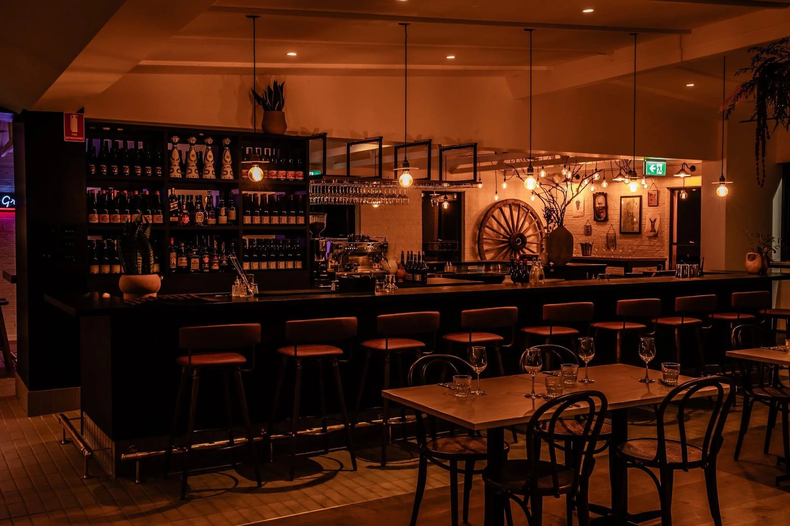Dining room with long bar counter, seating and wine bottle displays