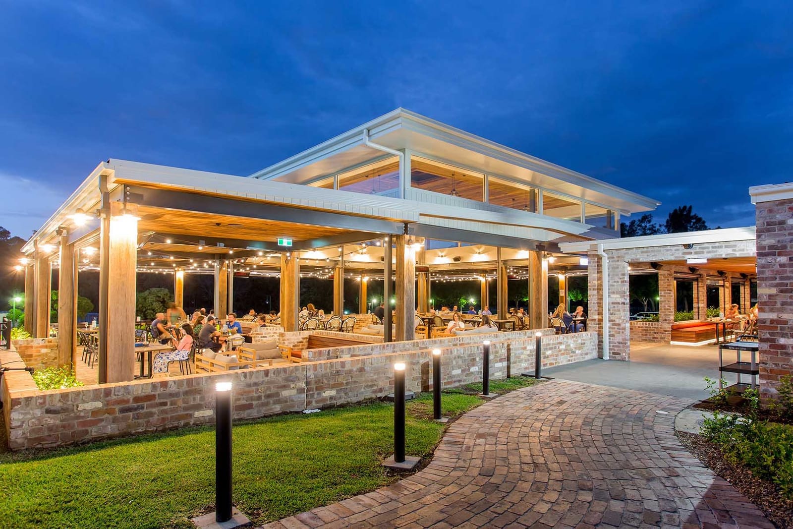 The all-weather alfresco area at dusk, strung with festoon lights and full of diners