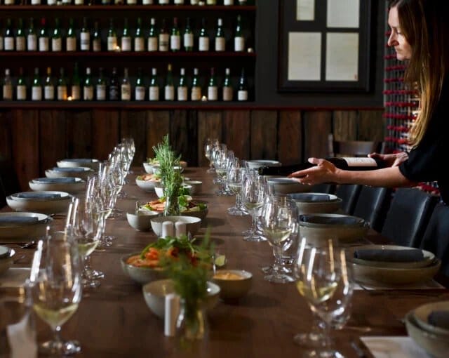 Dining table set for an event with wine glasses and food service