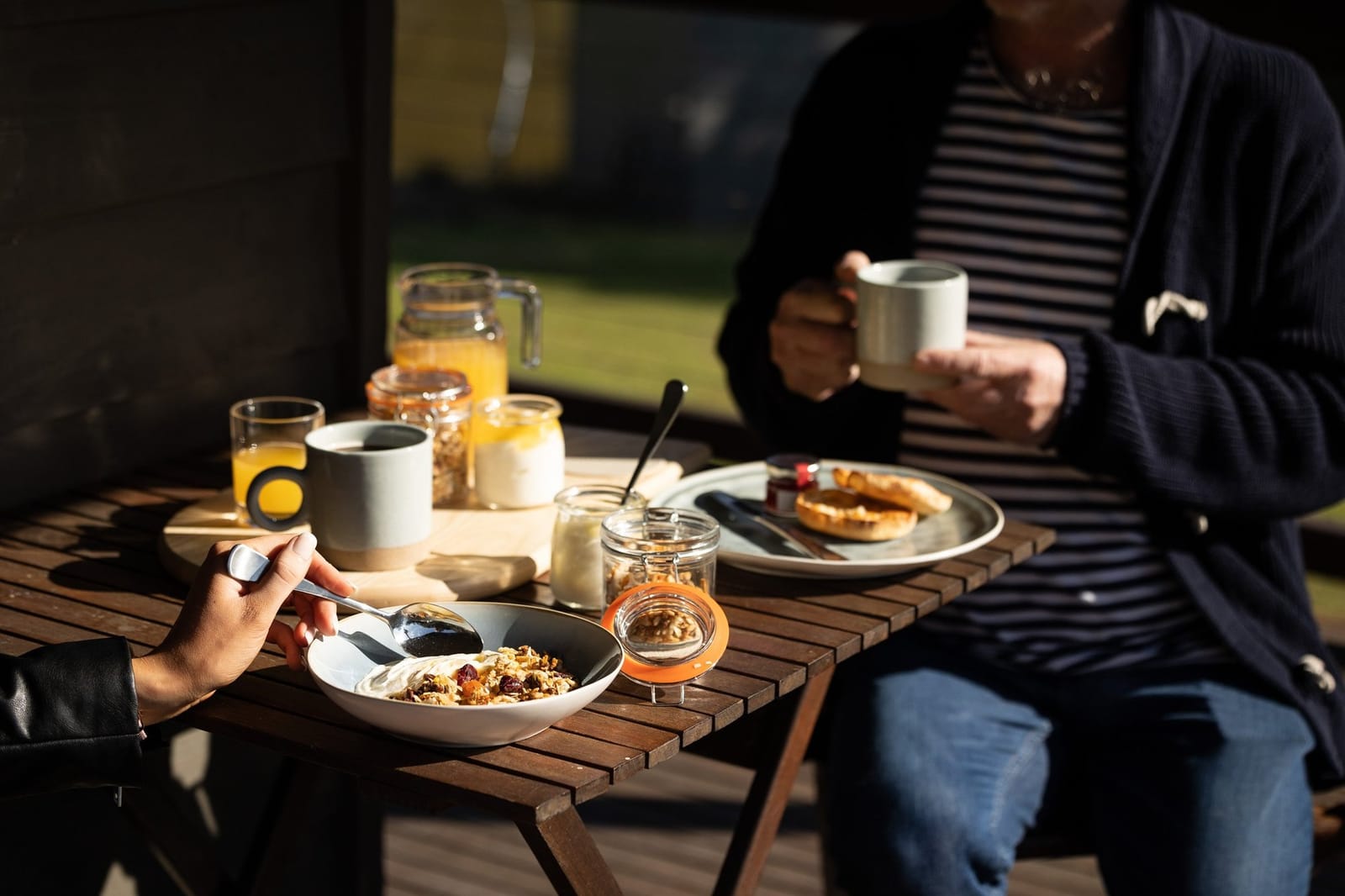 Guests dining outdoors with meal plates and drinks