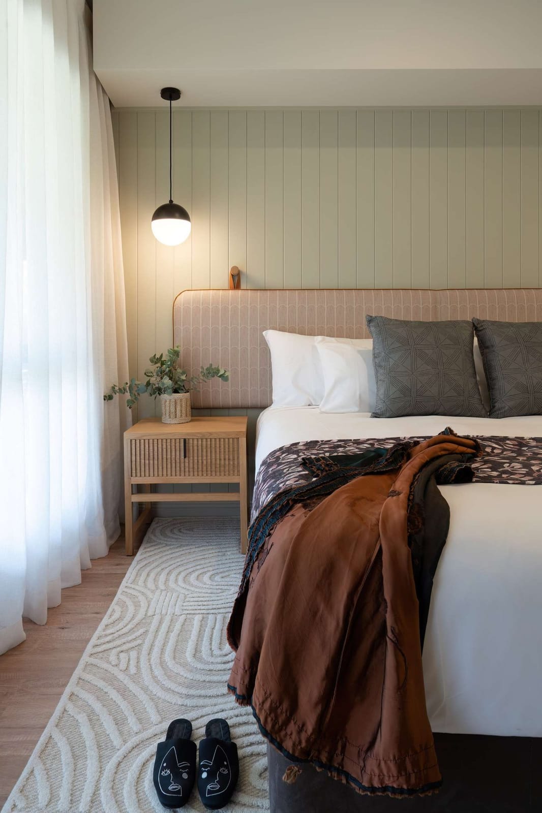 Modern bedroom with upholstered headboard and pendant light