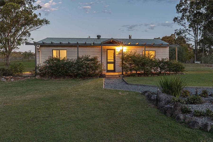 Hunter Gleann cottage exterior at dusk with lit windows and lawn